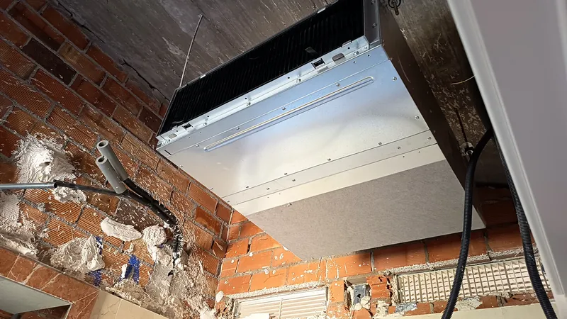 Unidad interior de conductos colgada del forjado durante la obra, antes de cerrar el falso techo